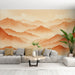 Un salon contemporain avec un papier peint représentant des montagnes aux dégradés de terracotta et beige, créant une ambiance chaleureuse et apaisante.