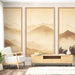 Un salon lumineux avec un papier peint représentant des montagnes en dégradé de beige et marron, créant une atmosphère apaisante et naturelle.
