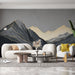 Un salon moderne avec un papier peint représentant des montagnes stylisées en noir et or sur fond gris, créant une ambiance élégante et apaisante.