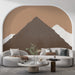 Un salon moderne avec un papier peint représentant des montagnes stylisées dans des teintes terreuses, créant une ambiance chaleureuse et apaisante.