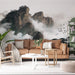 Un salon contemporain avec un papier peint représentant des montagnes majestueuses dans un paysage brumeux, créant une atmosphère apaisante et inspirante.