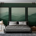 Une chambre moderne avec un papier peint représentant des montagnes en dégradés de verts, créant une atmosphère apaisante et naturelle.