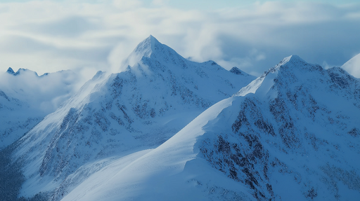Papier peint montagnes enneigées Paysage alpin majestueux sous un ciel nuageux