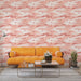 Un salon moderne avec un papier peint aux motifs de montagnes et nuages dans des teintes roses et blanches, créant une atmosphère douce et rêveuse.