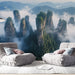 Papier peint panoramique montagnes mystérieuses avec pics émergeant des brumes pour salon moderne