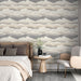 Une chambre élégante avec un papier peint aux motifs de nuages en dégradés de gris et beige, créant une atmosphère apaisante et moderne.