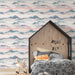 Une chambre enfantine avec un papier peint représentant des montagnes en dégradés de rose, bleu et vert, créant une atmosphère douce et apaisante.