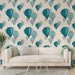 Un salon lumineux avec un papier peint représentant des montgolfières aux teintes turquoise et bleu clair sur un fond crème, créant une atmosphère aérienne et joyeuse.