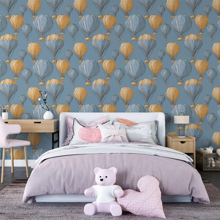 Une chambre enfantine avec un papier peint illustrant des montgolfières en bleu et or sur fond gris, créant une ambiance ludique et rêveuse.