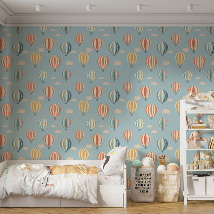 Une chambre d'enfant avec un papier peint illustrant des montgolfières colorées sur fond bleu clair, créant une ambiance joyeuse et rêveuse.