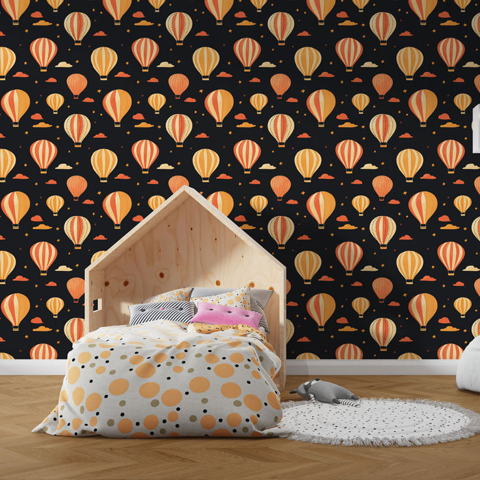 Une chambre d'enfant avec un papier peint illustrant des montgolfières colorées sur fond noir, créant une ambiance ludique et rêveuse.