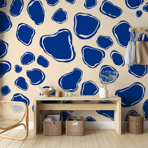 Une pièce moderne avec un papier peint abstrait aux formes organiques bleu marine sur fond beige, créant une ambiance dynamique et artistique.