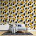 Une chambre moderne avec un papier peint artistique aux motifs abstraits en jaune et noir sur fond clair, créant une ambiance dynamique et chaleureuse.