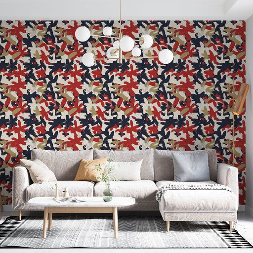 Un salon contemporain avec un papier peint aux motifs abstraits colorés dans des teintes de rouge, bleu marine et beige, créant une atmosphère dynamique et moderne.