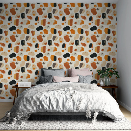 Une chambre moderne avec un papier peint abstrait aux motifs colorés orange, noir et beige, créant une ambiance chaleureuse et artistique.