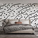 Une chambre moderne avec un papier peint graphique noir et blanc, présentant des lignes ondulées et des points, créant une ambiance dynamique et artistique.