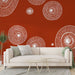 Un salon moderne avec un papier peint rouge orné de motifs circulaires blancs évoquant une ambiance artistique et dynamique.