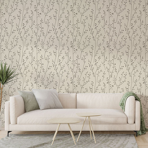 Un salon élégant avec un papier peint beige orné de délicates branches noires, créant une atmosphère apaisante et naturelle.