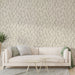 Un salon élégant avec un papier peint beige orné de délicates branches noires, créant une atmosphère apaisante et naturelle.