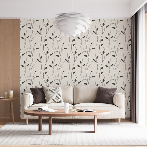 Un salon lumineux avec un papier peint aux motifs de branches noires délicates sur fond crème, créant une atmosphère douce et apaisante.