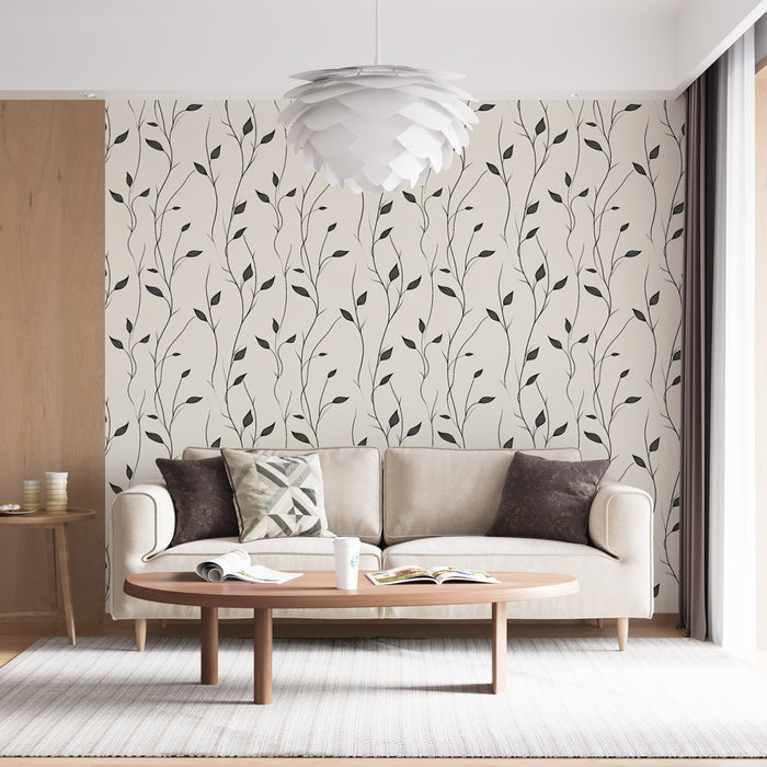 Un salon lumineux avec un papier peint aux motifs de branches noires délicates sur fond crème, créant une atmosphère douce et apaisante.