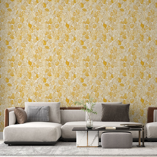 Un salon moderne avec un papier peint aux motifs de feuilles jaunes et beige sur fond clair, créant une ambiance chaleureuse et accueillante.