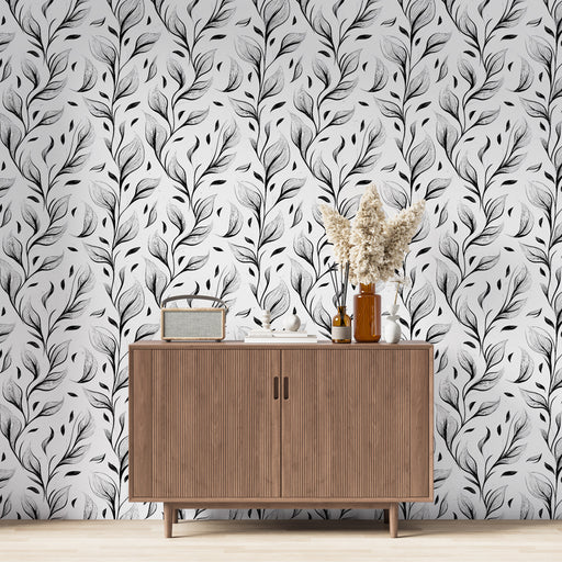 Une salle à manger moderne avec un papier peint noir et blanc aux motifs de feuilles délicates, créant une ambiance élégante et apaisante.