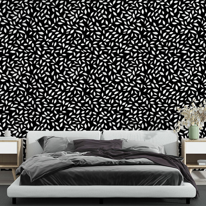 Une chambre moderne avec un papier peint noir orné de motifs de feuilles blanches, créant une ambiance élégante et dynamique.