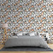 Une chambre moderne avec un papier peint aux motifs abstraits de formes organiques dans des teintes douces de pêche, vert et blanc, créant une ambiance chaleureuse et accueillante.