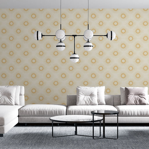 Un salon moderne avec un papier peint géométrique beige et doré, orné de motifs circulaires et de rayons, créant une ambiance chaleureuse et élégante.