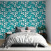 Une chambre moderne avec un papier peint aux motifs floraux stylisés bleu turquoise et blanc, créant une ambiance fraîche et dynamique.
