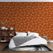 Une chambre moderne avec un papier peint terracotta orné de motifs floraux délicats en blanc, créant une atmosphère chaleureuse et accueillante.
