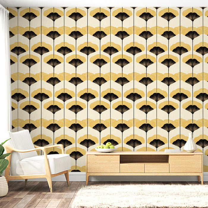 Un salon lumineux avec un papier peint au motif de feuilles noires et dorées sur fond crème, dégageant une ambiance élégante et moderne.