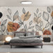 Une chambre moderne avec un papier peint aux motifs de feuilles délicates en noir et des touches de couleurs terreuses, créant une atmosphère apaisante et chaleureuse.