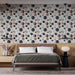Une chambre moderne avec un papier peint aux motifs de cercles variés dans des teintes de bleu, rose et beige, créant une ambiance artistique et dynamique.