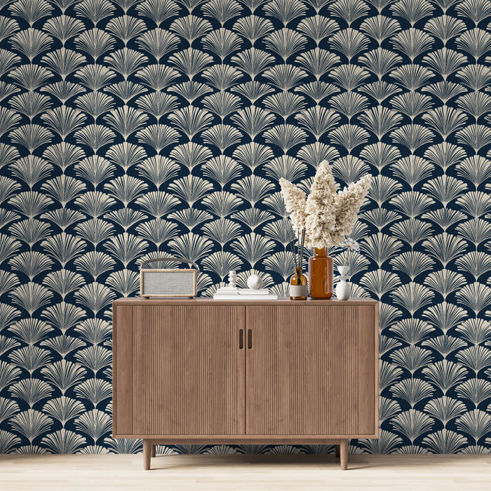 Un salon élégant avec un papier peint art déco bleu marine et doré, présentant des motifs de feuilles stylisées qui évoquent une atmosphère raffinée et chaleureuse.