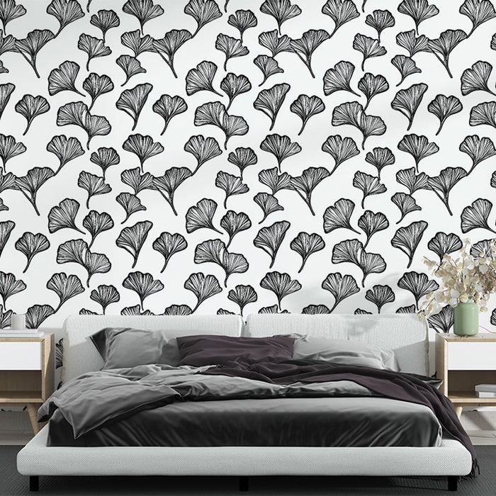 Une chambre moderne avec un papier peint noir et blanc représentant des feuilles de ginkgo, créant une atmosphère élégante et apaisante.