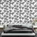Une chambre moderne avec un papier peint noir et blanc représentant des feuilles de ginkgo, créant une atmosphère élégante et apaisante.