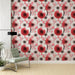 Un salon élégant avec un papier peint floral aux motifs de parasols rouges et noirs, agrémenté de fleurs roses sur fond clair, créant une ambiance artistique et chaleureuse.
