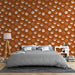 Une chambre moderne avec un papier peint terracotta orné de motifs graphiques blancs évoquant une ambiance chaleureuse et accueillante.