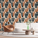 Une pièce moderne avec un papier peint aux motifs abstraits de cactus dans des teintes de bleu marine et terracotta sur fond crème, créant une atmosphère chaleureuse et accueillante.
