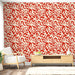 Un salon contemporain avec un papier peint aux motifs abstraits rouges et crème évoquant une ambiance dynamique et chaleureuse.