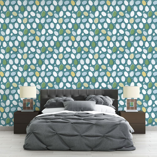 Une chambre moderne avec un papier peint aux motifs de formes ovales colorées sur fond bleu, créant une ambiance fraîche et joyeuse.