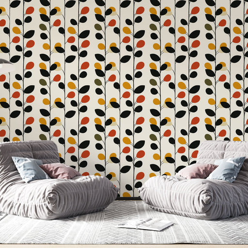 Un salon moderne avec un papier peint aux motifs de feuilles stylisées en noir, rouge, jaune et vert sur fond clair, créant une ambiance chaleureuse et dynamique.