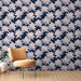 Une chambre moderne avec un papier peint floral représentant des nénuphars roses sur fond bleu marine, créant une atmosphère apaisante et élégante.