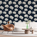 Un salon moderne avec un papier peint floral bleu marine orné de grandes fleurs de lotus blanches, créant une ambiance apaisante et élégante.