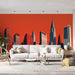Une pièce moderne avec un papier peint représentant une silhouette de gratte-ciels noirs sur fond orange vif, créant une ambiance dynamique et urbaine.
