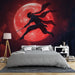 Une chambre moderne avec un papier peint représentant un personnage en mouvement devant une grande lune rouge, créant une ambiance dynamique et mystérieuse.