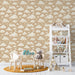 Une chambre d'enfant avec un papier peint beige orné de nuages blancs, créant une atmosphère douce et rêveuse, idéale pour l'éveil et l'imagination.