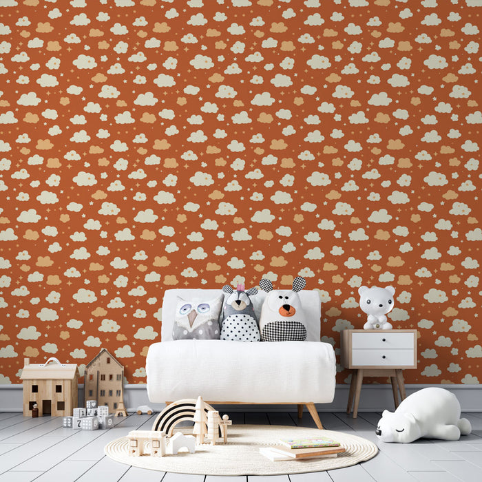 Une chambre d'enfant avec un papier peint terracotta orné de nuages crème et de petites étoiles, créant une atmosphère douce et ludique.